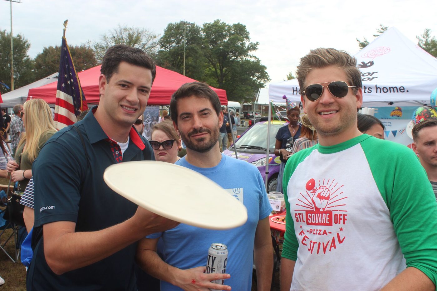 Three men holding pizza dough at the STL Square Off Pizza Festival